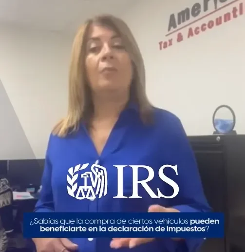 Woman standing in front of camera wearing a blue business shirt. In the background there is a white wall with the America Tax & Accounting, Corp. Logo.